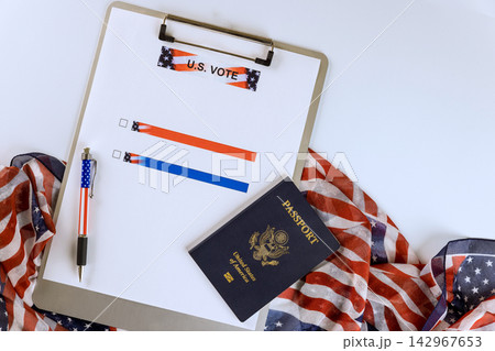US passport, ballot on clipboard lay on an American flag voting essentials. US passport, ballot on clipboard lay on an American flag voting essentials. 142967653