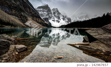 Snowy Mountain Lake Reflection in Misty Alpine Landscape Snowy Mountain Lake Reflection in Misty Alpine Landscape 142967657