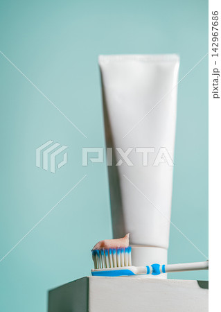 A toothbrush with a dab of pink toothpaste 142967686