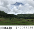 曇り空の下に広がる緑の田園と里山 142968286