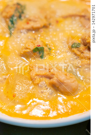 Creamy chicken curry with herbs and chili, close up food texture Creamy chicken curry with herbs and chili, close up food texture 142971701