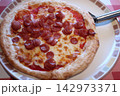 とろけるチーズとソーセージがのった出来立てのピザ とろけるチーズとソーセージがのった出来立てのピザ 142973371