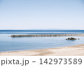 夏の穏やかな青い海と澄み渡る青空 砂浜と突堤の海岸風景 142973589