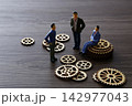 Miniature business people discussing teamwork and strategy planning 142977043