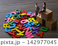 Miniature people standing next to colorful alphabet letters 142977045