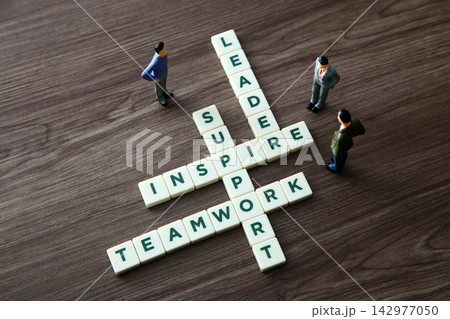 Miniature figures interacting with crossword puzzle words leadership, inspire, support, teamwork Miniature figures interacting with crossword puzzle words leadership, inspire, support, teamwork 142977050