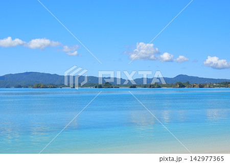 沖縄の古宇利ビーチの青空を映した鏡のような海の絶景 沖縄の古宇利ビーチの青空を映した鏡のような海の絶景 142977365