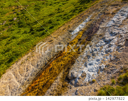 Colorful Mineral Deposits around Iron Seep on Rocky Hillside in Kyrgyzstan Colorful Mineral Deposits around Iron Seep on Rocky Hillside in Kyrgyzstan 142977822