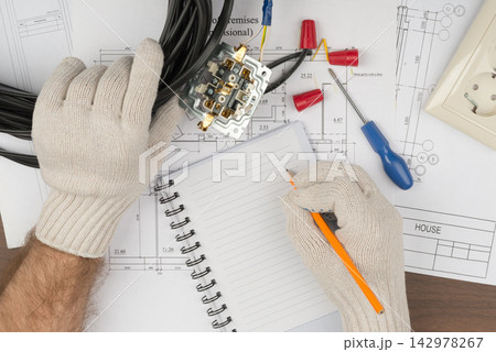 Electrician Wiring Installation on House Blueprint with Tools 142978267