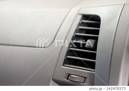 Car Air Vent Close-Up on Gray Dashboard Interior Car Air Vent Close-Up on Gray Dashboard Interior 142978373