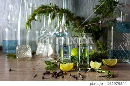 Gin is poured from a bottle into a glass. 142979844