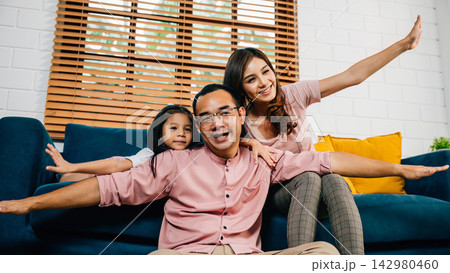 An interracial family shares a heartwarming moment at home playing plane games with their daughter An interracial family shares a heartwarming moment at home playing plane games with their daughter 142980460