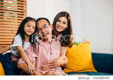 A joyful family in their comfortable modern house enjoys quality time on the sofa 142980467