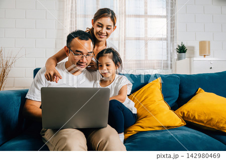 Parents and kids gathered on the couch with a laptop finding happiness in their modern family time 142980469