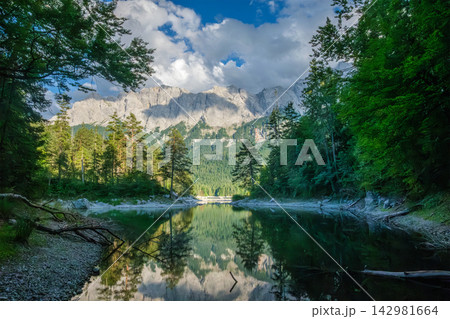 Mountain reflection in Eibsee lake framed by forest trees in Bavaria Mountain reflection in Eibsee lake framed by forest trees in Bavaria 142981664
