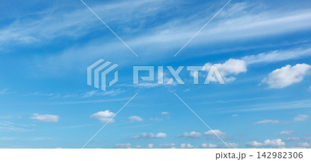 Serene sky view with soft clouds on a clear blue summer day Serene sky view with soft clouds on a clear blue summer day 142982306