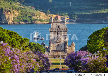Scenic view of Belem Tower framed by blooming jacaranda trees in Lisbon Scenic view of Belem Tower framed by blooming jacaranda trees in Lisbon 142982801
