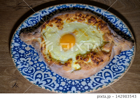 Adjarian Khachapuri Georgian boat shaped cheese bread topped with a raw egg yolk and butter Adjarian Khachapuri Georgian boat shaped cheese bread topped with a raw egg yolk and butter 142983543