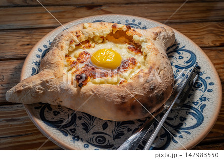 Adjarian Khachapuri Georgian boat shaped cheese bread topped with a raw egg yolk and butter Adjarian Khachapuri Georgian boat shaped cheese bread topped with a raw egg yolk and butter 142983550