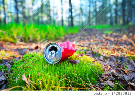 Crumpled red aluminum soda can in Wild. Can is discarded on forest floor Crumpled red aluminum soda can in Wild. Can is discarded on forest floor 142983912