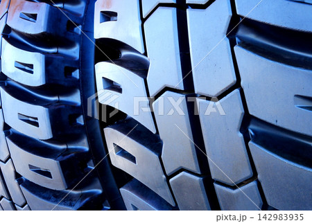 Tire background. New Tyres for lorry. Wheel assembly. Tires for mining truck close up Tire background. New Tyres for lorry. Wheel assembly. Tires for mining truck close up 142983935