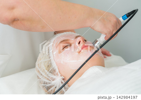 Client experiencing RF lifting treatment for skin rejuvenation in beauty clinic 142984197