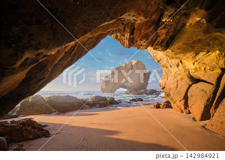 Beautiful sunset view of Penedo do Guincho rock arch at Praia da Santa Cruz Beautiful sunset view of Penedo do Guincho rock arch at Praia da Santa Cruz 142984921