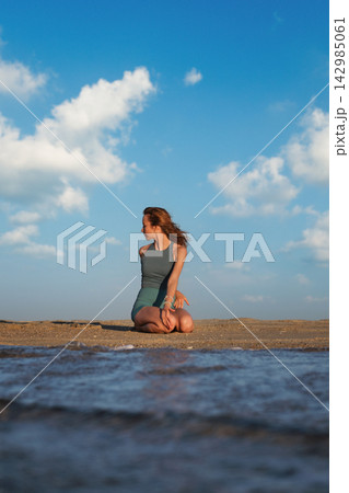 Bharadvajasana Variation Yoga in Vajrasana on Beach at Golden Hour Bharadvajasana Variation Yoga in Vajrasana on Beach at Golden Hour 142985061