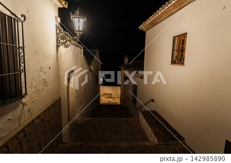Softly lit stone stairway winds down a whitewashed alley at night in Ronda Softly lit stone stairway winds down a whitewashed alley at night in Ronda 142985890
