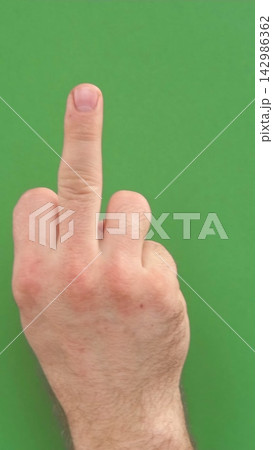 Abusive gesture fuck on chromakey. Male hand shows middle finger, offensive gesture isolated on green background. Fuck You concept. Close Up. Bad expression, provocation. Rude attitude. Fuck off sign Abusive gesture fuck on chromakey. Male hand shows middle finger, offensive gesture isolated on green background. Fuck You concept. Close Up. Bad expression, provocation. Rude attitude. Fuck off sign 142986362