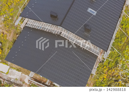 dark gray roof of an industrial building made of metal. Corrugated metal roof and metal roofing. Modern roof made of met dark gray roof of an industrial building made of metal. Corrugated metal roof and metal roofing. Modern roof made of met 142988818