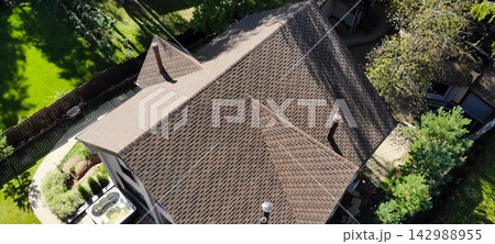Bituminous tile for a roof. a roof from a bituminous tile. Modern roof made of met 142988955