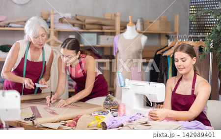 Young tailor sewing, senior and adult employee assistant drawing paper dress pattern by curves 142989401