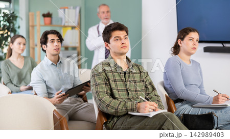 Students listen to lecture in classroom, with medical professor in background Students listen to lecture in classroom, with medical professor in background 142989403