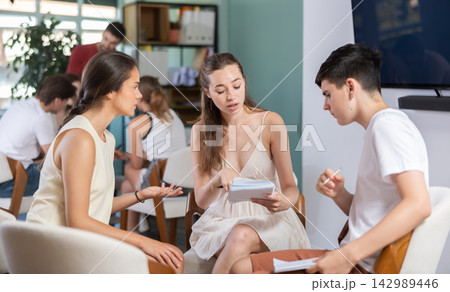 Two teams debating and discussing with teacher as game host in classroom Two teams debating and discussing with teacher as game host in classroom 142989446
