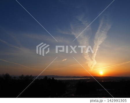 猪苗代湖対岸に沈む夕日。オレンジ色に染まる地平線と白い雲が青空に印象的で綺麗だ。 猪苗代湖対岸に沈む夕日。オレンジ色に染まる地平線と白い雲が青空に印象的で綺麗だ。 142991305