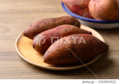 Steamed orange sweet potatoes on wooden plate ready to eat, healthy food 142991422