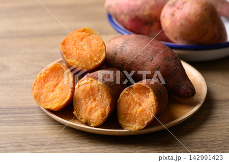 Steamed orange sweet potatoes on wooden plate ready to eat, healthy food 142991423