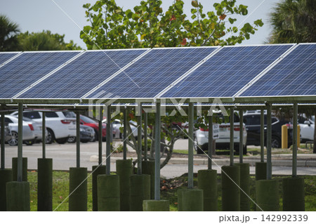 Solar panels installed on stand frame near parking lot for effective generation of clean electricity. Photovoltaic technology integrated in urban infrastructure for electric car charging Solar panels installed on stand frame near parking lot for effective generation of clean electricity. Photovoltaic technology integrated in urban infrastructure for electric car charging 142992339