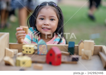 preschool child girl playing with wooden toy block at outdoor 142992446