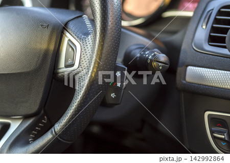 Luxurious car interior. Dashboard and steering wheel in black gray color. Transportation, design, modern technology concept.ultiple Values) Luxurious car interior. Dashboard and steering wheel in black gray color. Transportation, design, modern technology concept.ultiple Values) 142992864