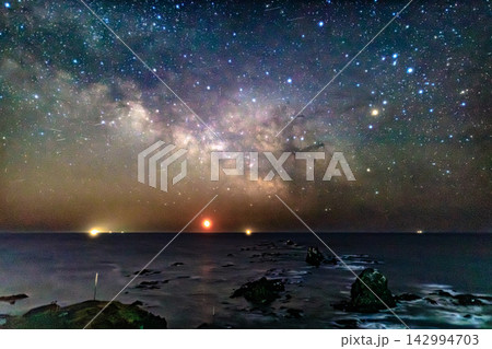 極東の夜空に広がる煌めく天の川と地平線の明かりが織りなす星空風景 極東の夜空に広がる煌めく天の川と地平線の明かりが織りなす星空風景 142994703
