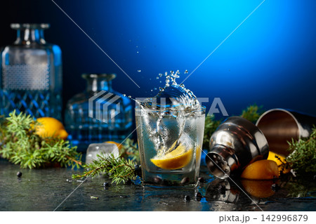 Gin and tonic cocktail with juniper branches on a black stone table. Gin and tonic cocktail with juniper branches on a black stone table. 142996879