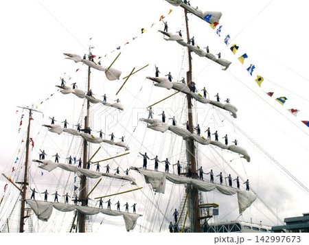 Tall Ship Crew Standing on Rigging with Signal Flags Tall Ship Crew Standing on Rigging with Signal Flags 142997673