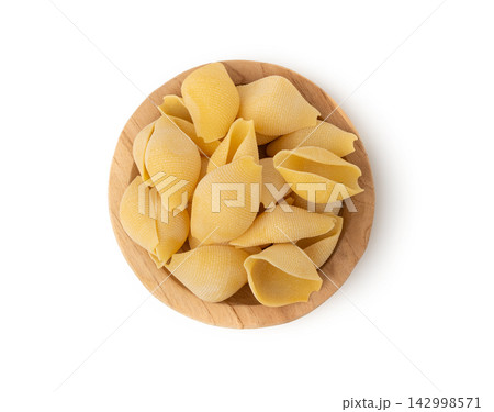 Raw conchiglioni pasta isolated. Dry conchiglie noodle in shell shape, big Italian macaroni Raw conchiglioni pasta isolated. Dry conchiglie noodle in shell shape, big Italian macaroni 142998571