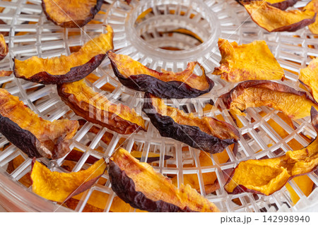 Dried nectarines and peaches in fruit dryer close up 142998940