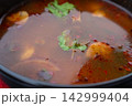 Tom yum thai soup with chicken in black bowl 142999404