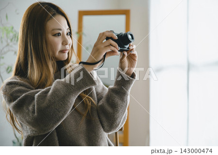 秋冬のシーンでデジタルカメラで写真を撮る美しい日本人女性 秋冬のシーンでデジタルカメラで写真を撮る美しい日本人女性 143000474