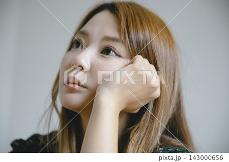 ダイニングテーブルに頬をつけてリラックスする美しい日本人女性 ダイニングテーブルに頬をつけてリラックスする美しい日本人女性 143000656