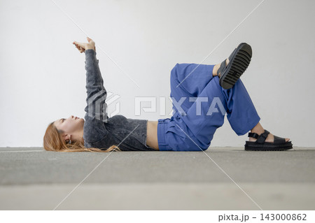 床に仰向けでストレッチと瞑想をする美しい日本人女性 143000862